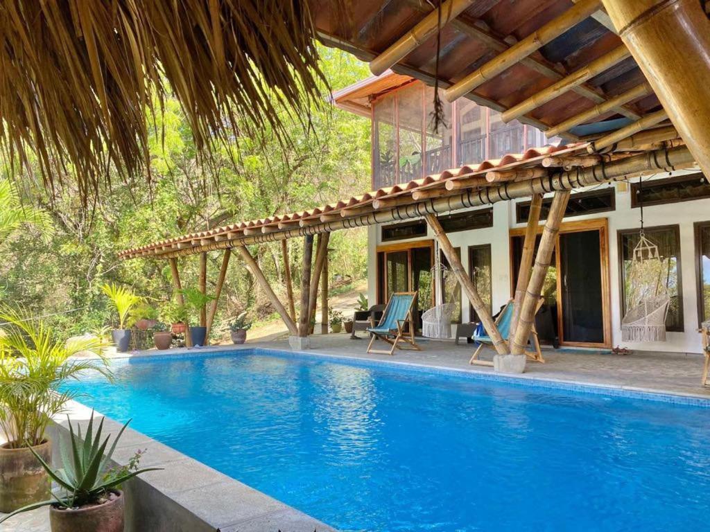 a swimming pool in front of a house at The Sanctuary Wellness Resort in Escameca