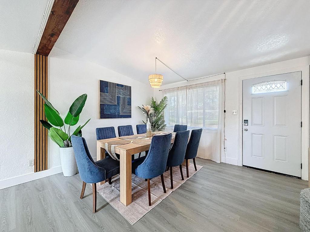 a dining room with a wooden table and blue chairs at Modern 3BR Retreat with Pool & Fire Pit in Largo