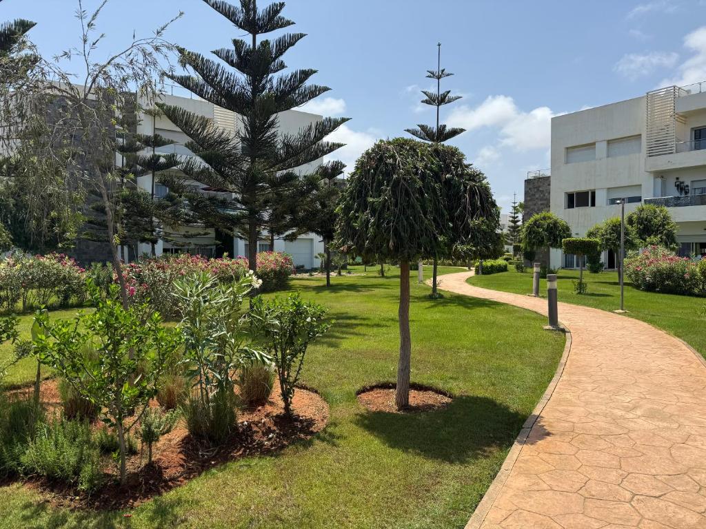 a park with trees and plants in front of a building at Appartement F2, Perla saidia - plage a 5 min à pieds - Piscine en travaux in Saidia 