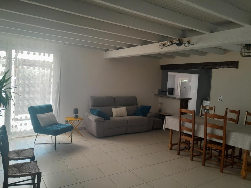 a living room with a couch and a table and chairs at Place Georges Brassens in Cahors