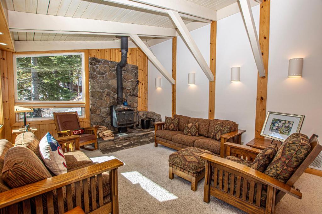 a living room with couches and a stone fireplace at KT22 View By Hauserman Rentals in Olympic Valley
