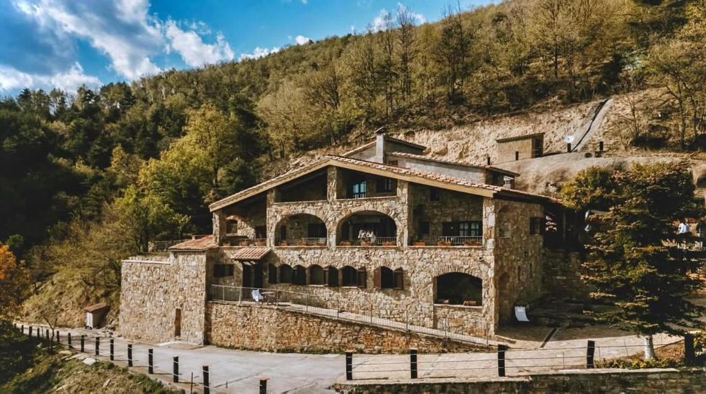 a stone house on the side of a mountain at Turisme Rural Mas Isoles in Ripoll