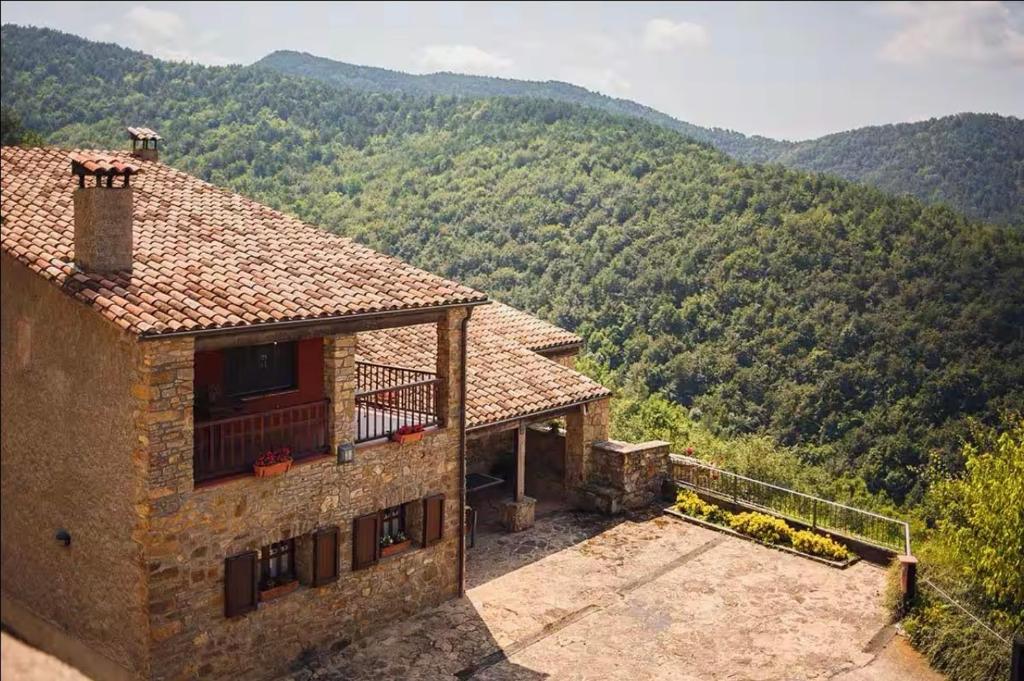 ein Gebäude mit einem Balkon und Bergblick in der Unterkunft Turisme Rural Mas Isoles in Ripoll