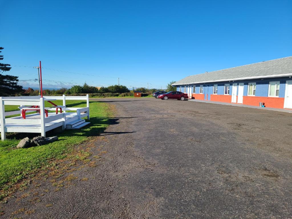 a parking lot with a white fence and a building at Countryview Motel & Restaurant in Berrys Mills