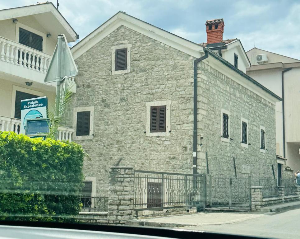 a gray brick building with a fence in front of it at Villa#12 in Savina