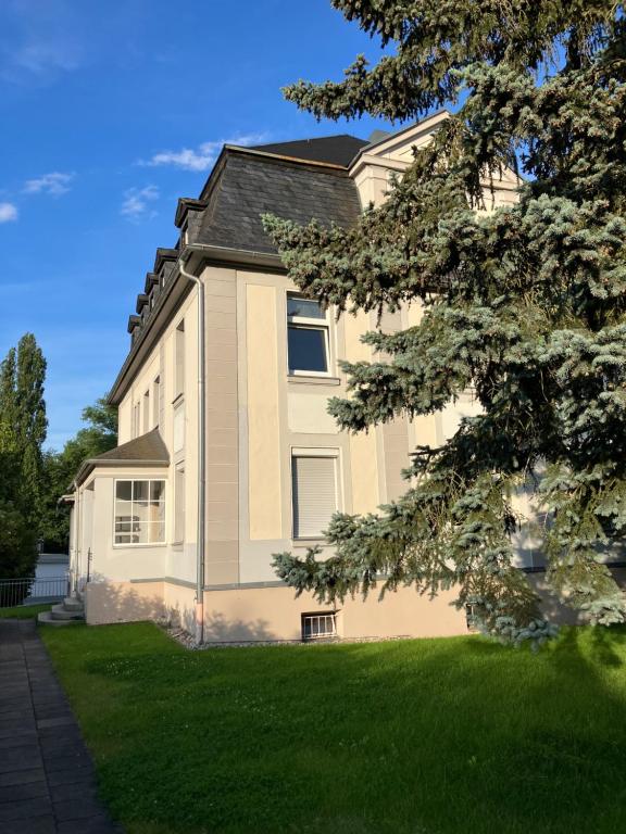 a large house with a green lawn in front of it at Ferienwohnung am Saaleknie in Rudolstadt