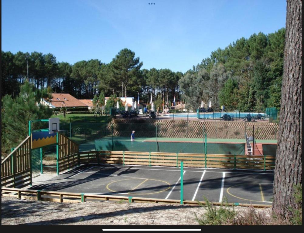 a tennis court with a tennis player on it at Petite maison dans les Landes in Saint-Julien-en-Born