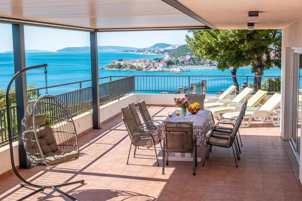 ein Balkon mit Tisch und Stühlen und dem Meer in der Unterkunft Apartments Sinovcic with terrace & sea view, 4 min walk to the beach in Podstrana