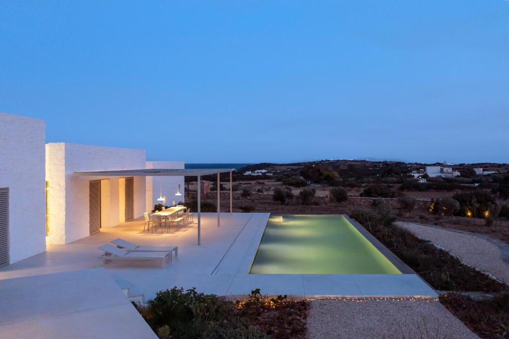 a villa with a swimming pool at night at MedBlu Paros in Paros National Airport