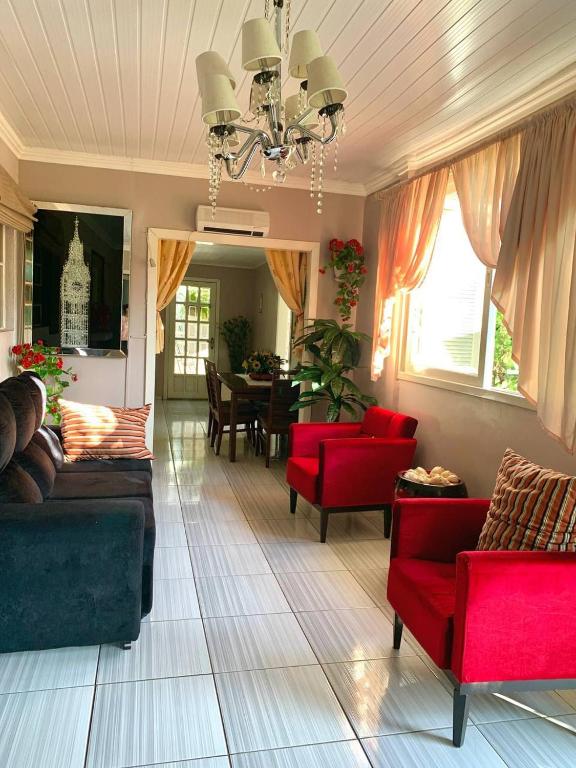 a living room with red furniture and a dining room at Casa dei Nonni in Garibaldi