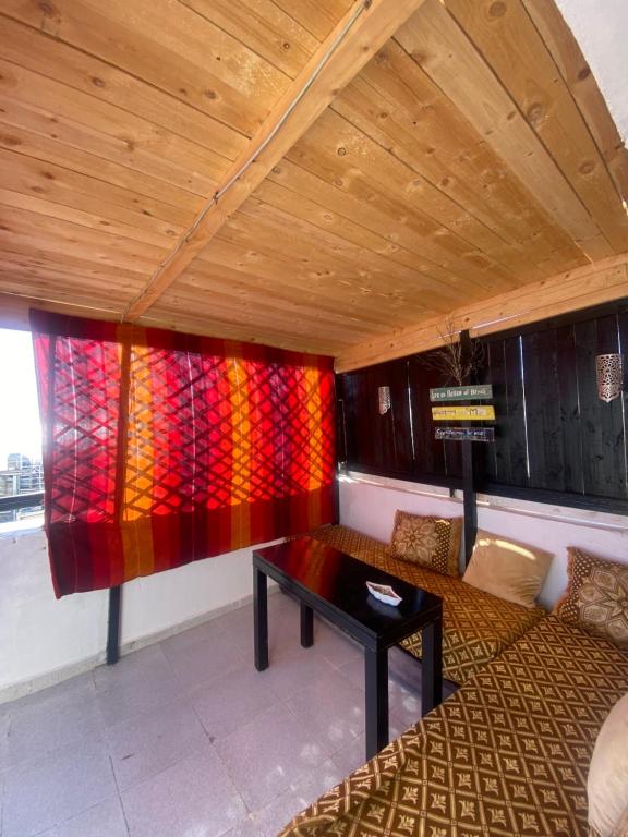 Zimmer mit Sofa und Tisch in der Unterkunft Taghazout studio & rooftop in Taghazout