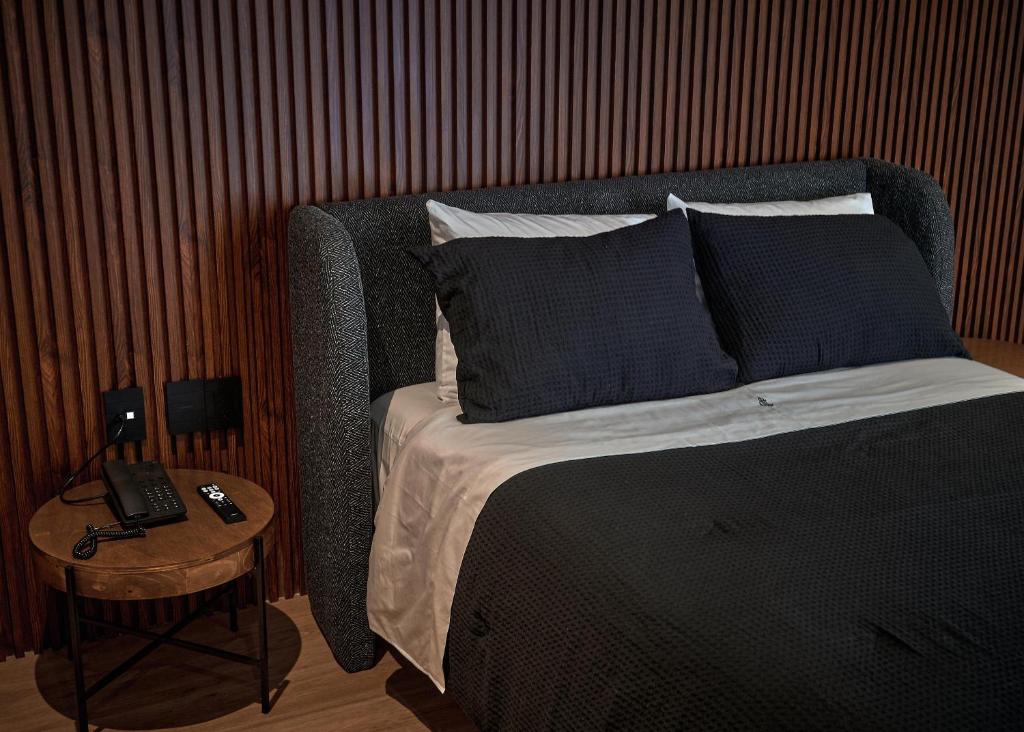 a bedroom with a bed and a table with a phone at Casa Irene Hotel Boutique y Spa in San Luis Potosí