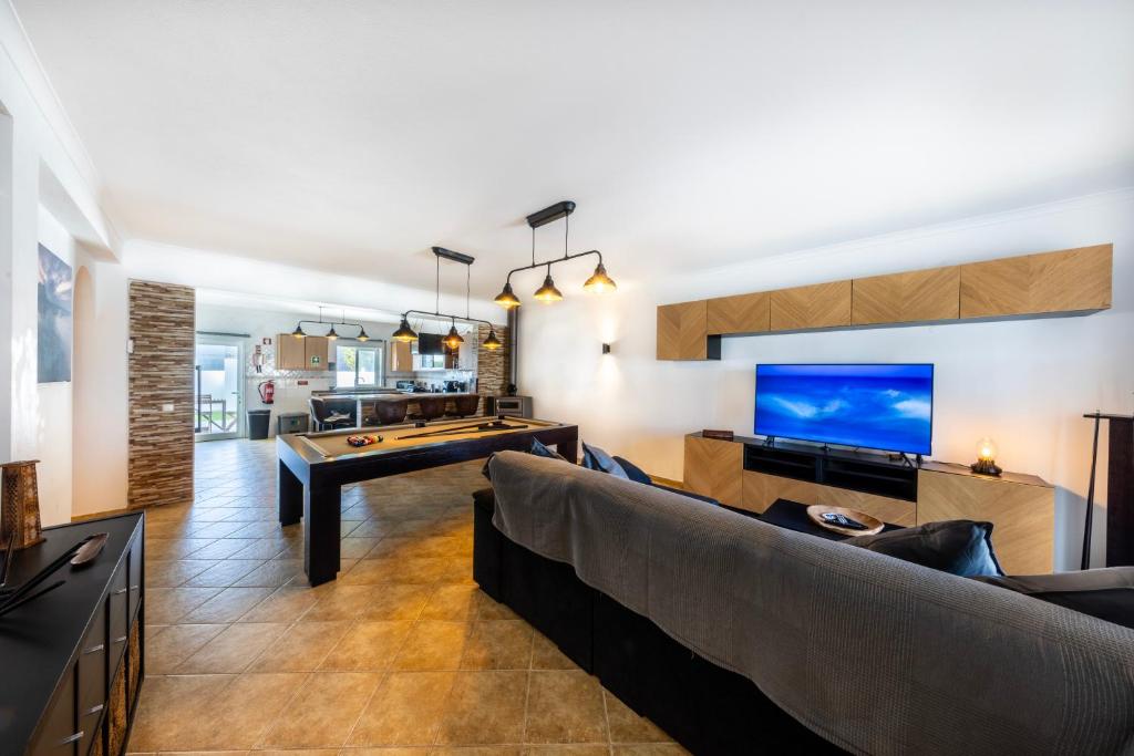 a living room with a couch and a pool table at Sagres ZEN - 3 Bedroom House in Sagres