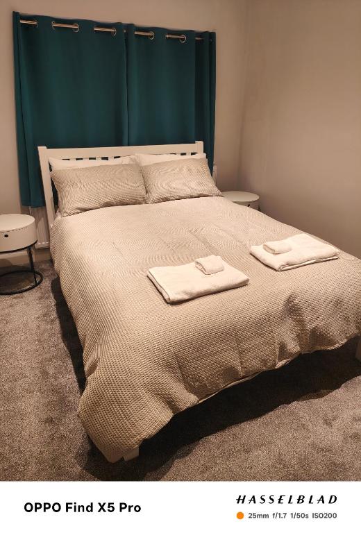 a bedroom with a bed with two towels on it at Stunning maisonette available in Watford