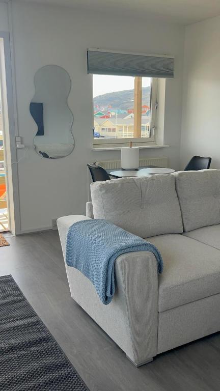 a living room with a couch with a blue towel on it at Ilulissat City Apartments- Apartment 2 in Ilulissat