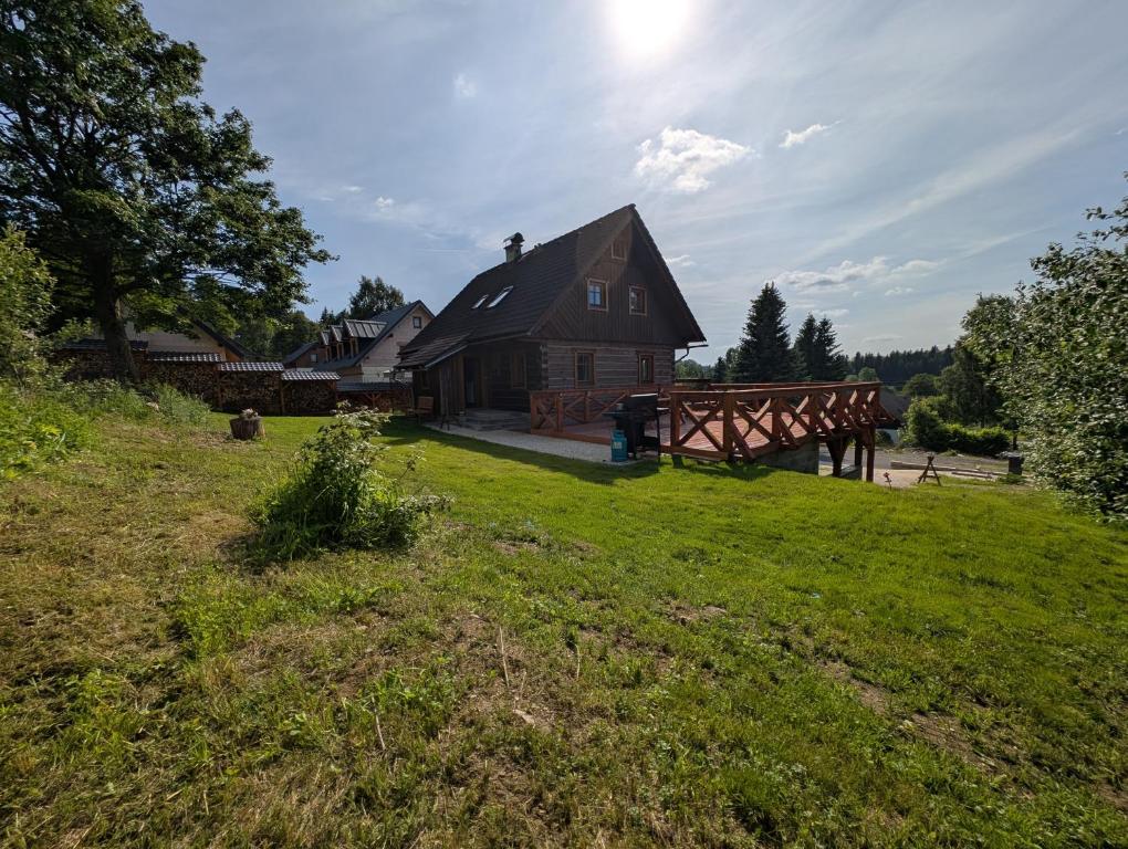 a house on a hill with a grassy yard at Chalet Kočí in Kořenov