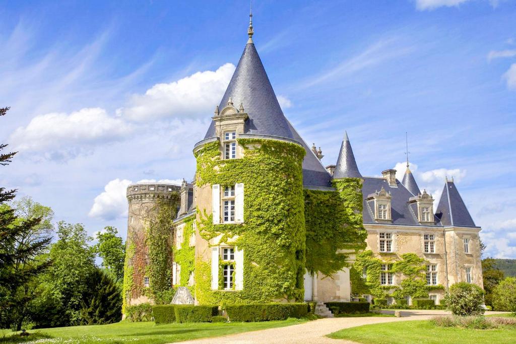 un antiguo castillo con una torre y hiedra en Hôtel & SPA Château de La Côte - Brantôme, en Biras