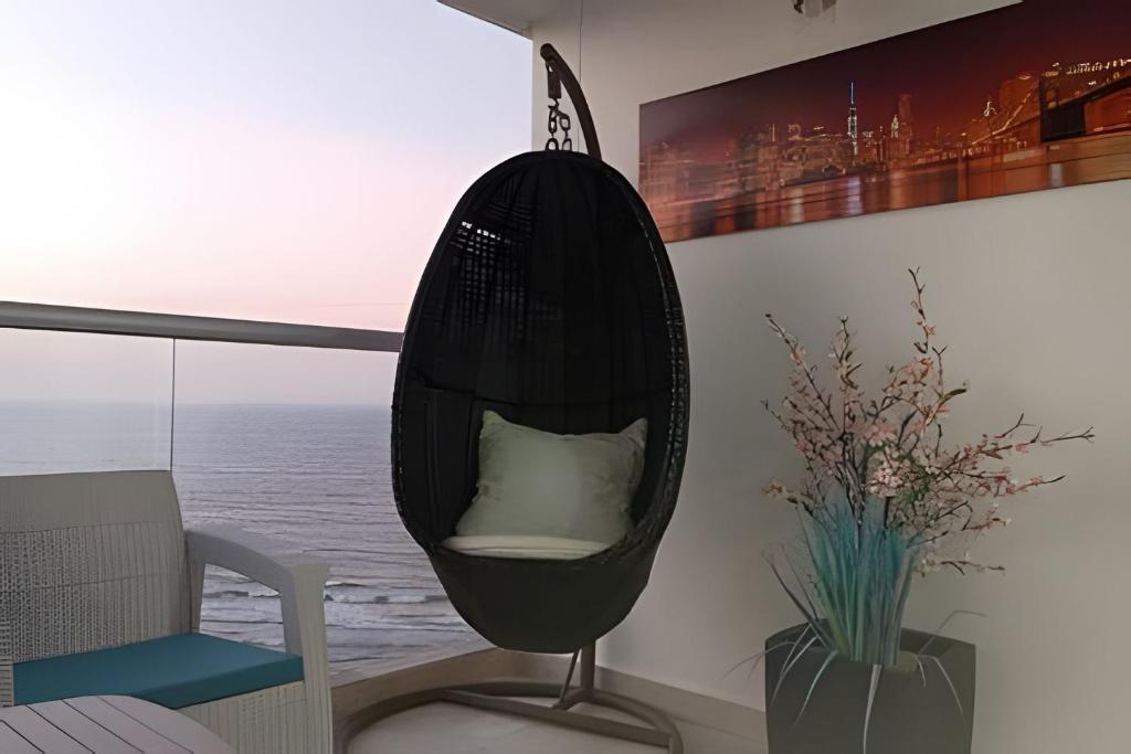 卡塔赫纳Aparta Suite - Vista al Mar/416的客厅里有一张带枕头的黑色摇椅