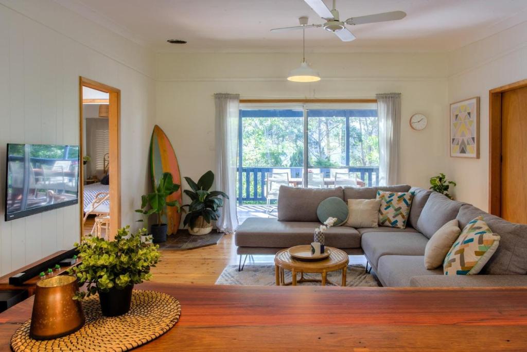 una sala de estar con un sofá y una mesa en Macs Beach Bungalow, en Macmasters Beach