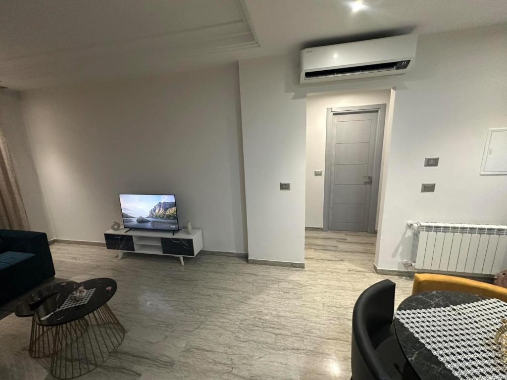 a living room with a tv and a couch at Casa de Yassine in Hammamet Nord