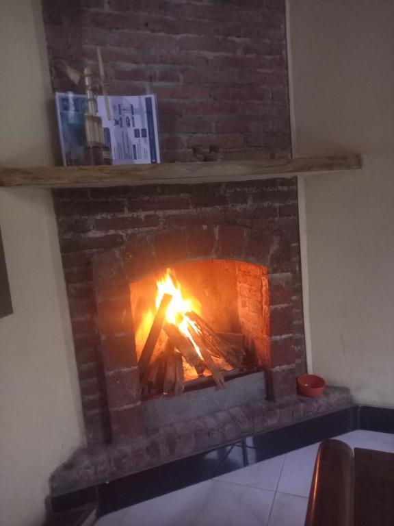 a brick fireplace with a fire in it at Homestay RnJ in Licin