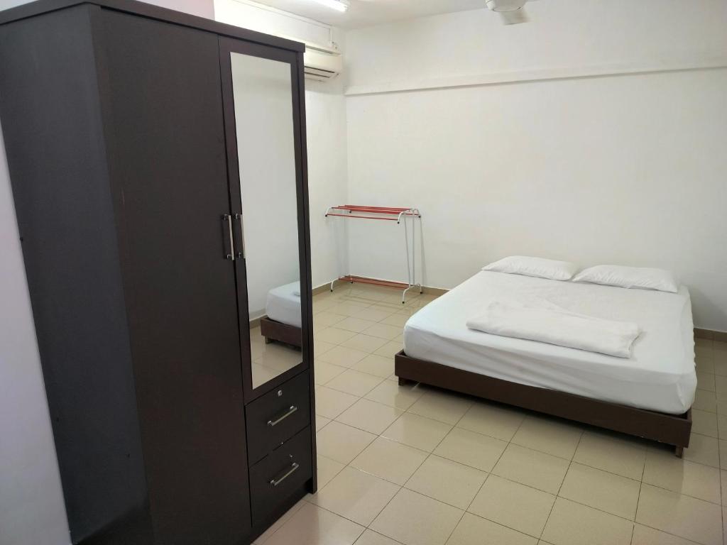 a bedroom with a bed and a dresser and a mirror at Travellers Space 2 in Kuantan