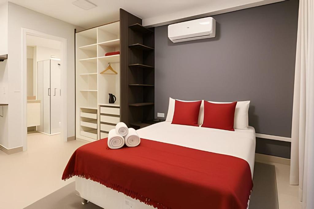 ein Schlafzimmer mit einem großen Bett mit roten Kissen in der Unterkunft Studio moderno próximo ao metrô Republica in São Paulo