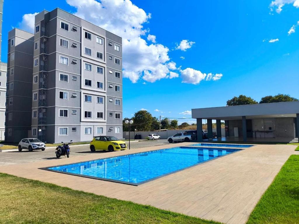 a building with a swimming pool in front of a building at Apartamento de 02 quartos com vista para o lago in Palmas