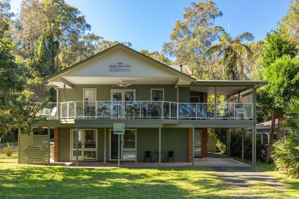 a house with a balcony on the front of it at Amaroo Sunset Lodge in Smiths Lake