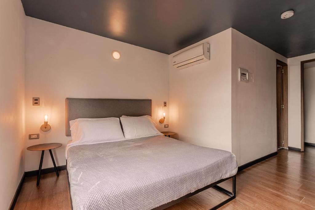 a bedroom with a large bed and a table at Soy Local Parque La 93 in Bogotá
