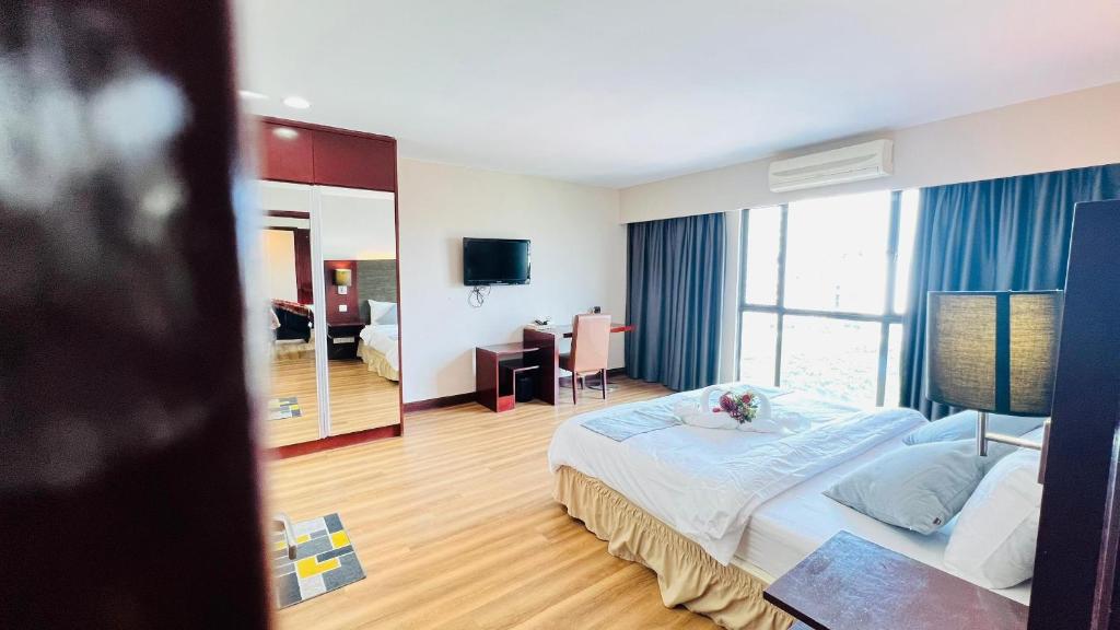 a hotel room with a large bed and a desk at Ming Garden The Nala Suite Kota Kinabalu in Kota Kinabalu