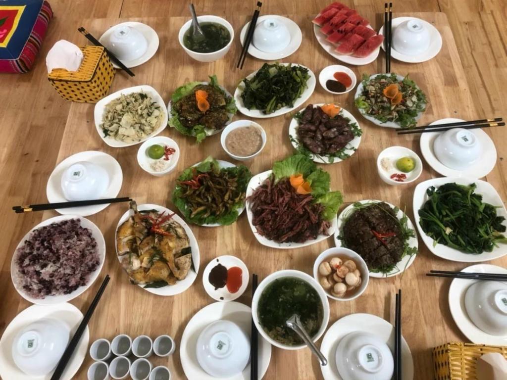 a table full of plates of food on a table at Hải Long Homestay in Làng Chan Han