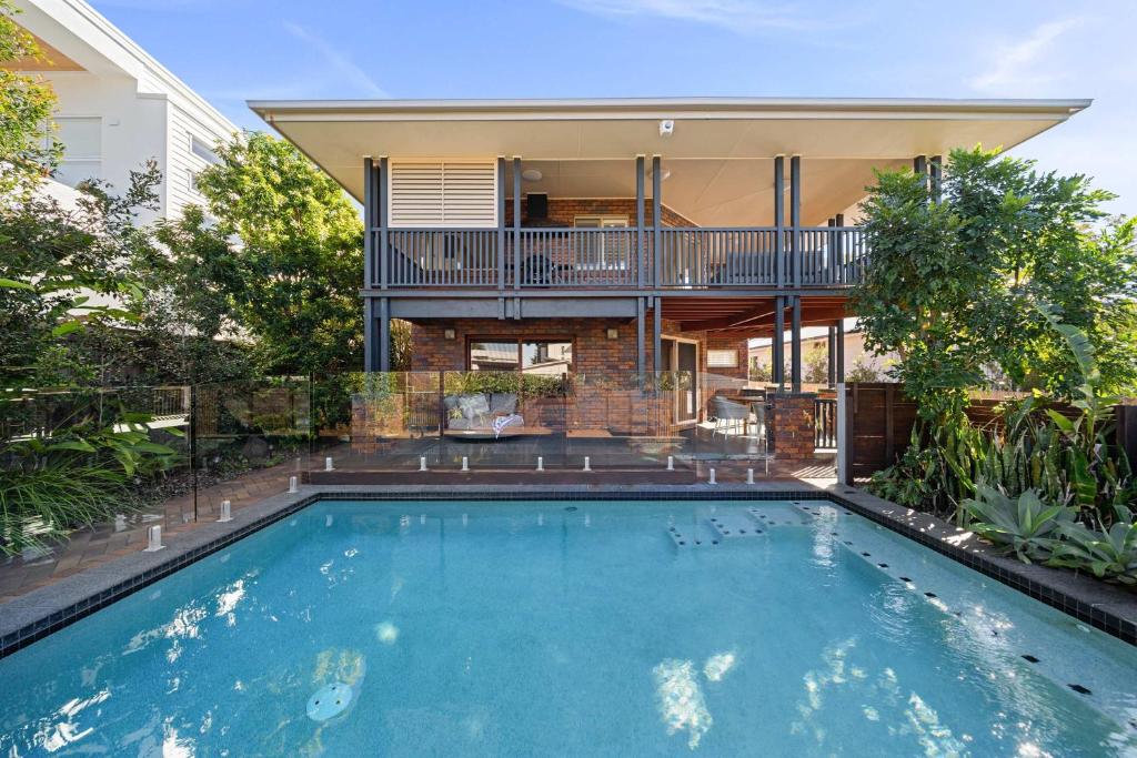 a swimming pool in front of a house at The Acacia Family Getaway in Shelly Beach in Caloundra
