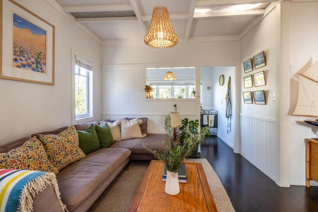 un salon avec un canapé et une table dans l'établissement Driftwood Cottage, à Waiheke Island