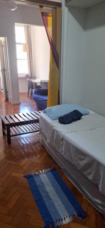 a bedroom with a bed and a wooden floor at Apê em Copacabana in Rio de Janeiro