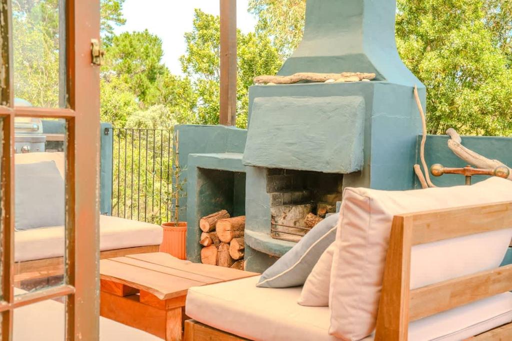 a patio with a fireplace and a table and chairs at Casa Del Mar in Waiheke Island