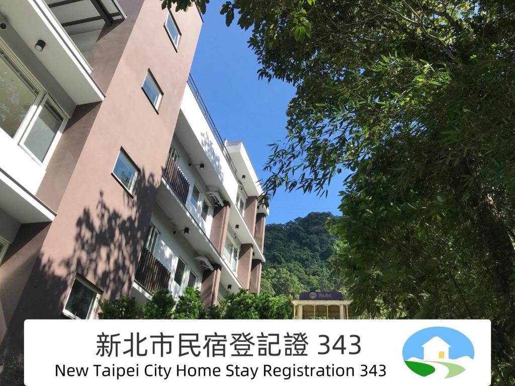 乌来乌来足立司拉温泉会馆的城市中的一栋建筑，上面写着 新电车城微型民宿登记