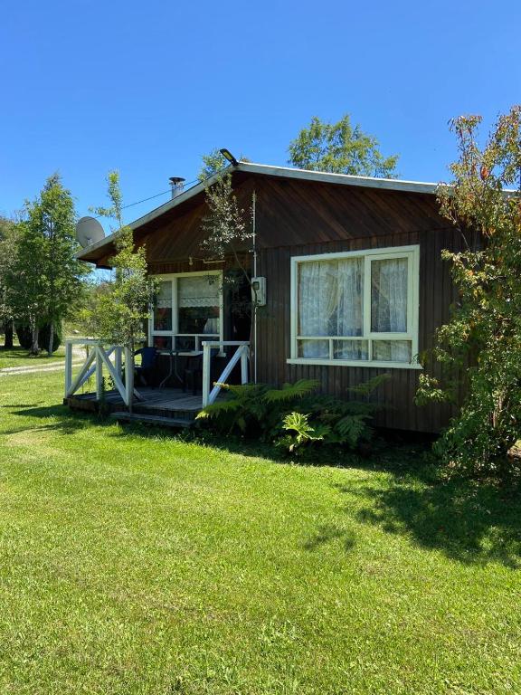 a small house with a porch and a yard at Cabañas Campestres Villarrica in Villarrica