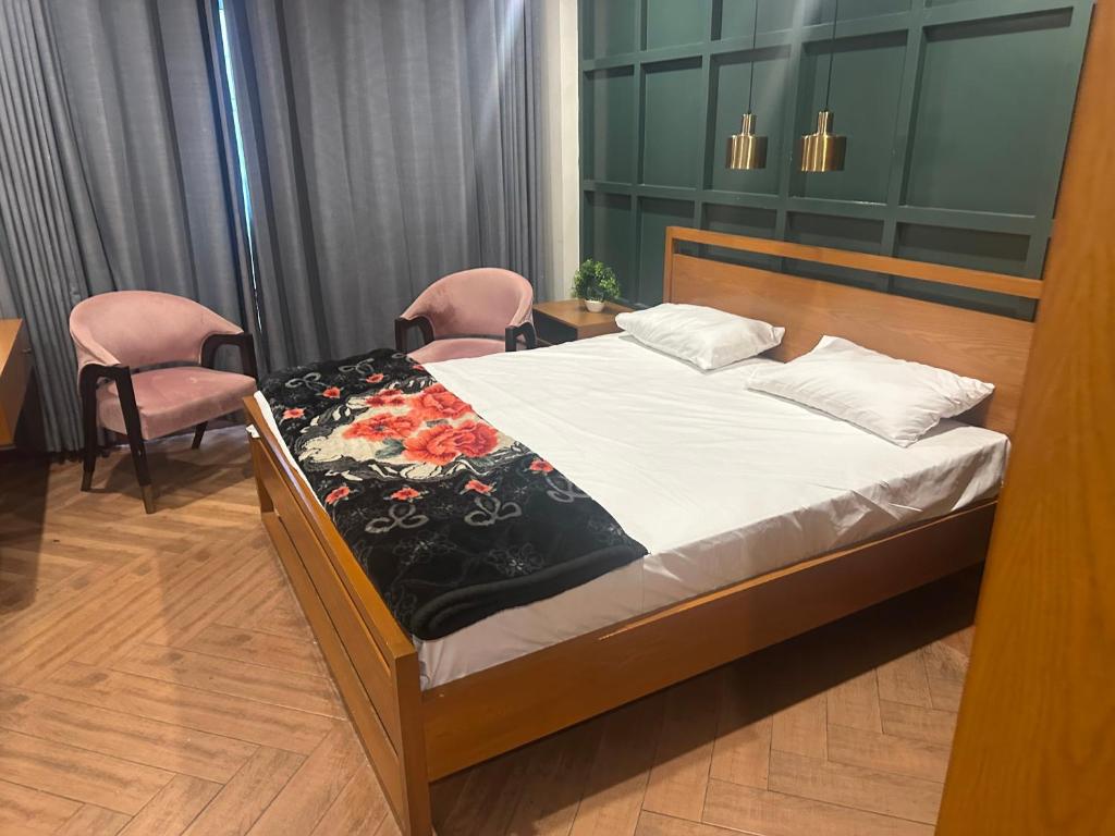 Cama en habitación con 2 sillas y cama sidx sidx sidx sidx en Arcadian luxury Apartment, en Rawalpindi