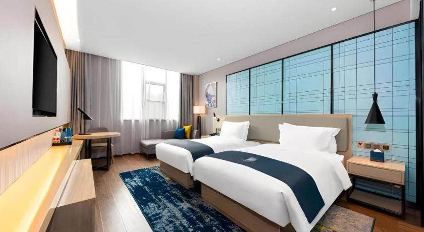 Ένα ή περισσότερα κρεβάτια σε δωμάτιο στο Echarm Hotel Wuhan Plaza Wansongyuan