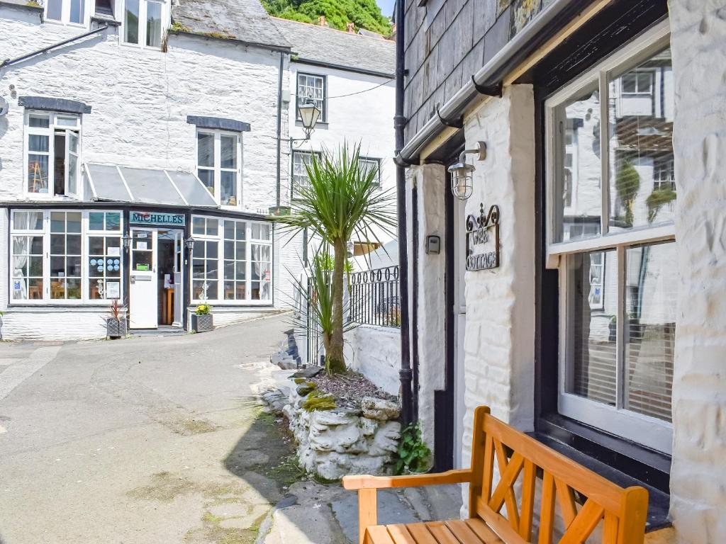 a wooden bench sitting outside of a building at The Wee Cottage in Polperro
