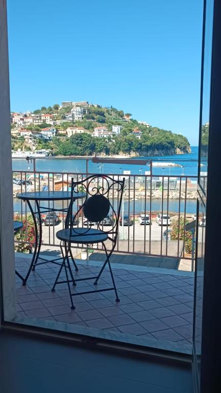 a table and chair on a balcony with a view of the beach at La voce del mare in Agropoli
