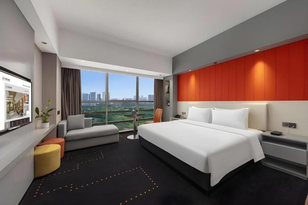 a hotel room with a large bed and a television at Aishang Hotel (Lecong Furniture Mall, Foshan) in Shunde