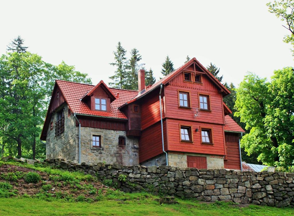 ein rotes Haus auf einer Steinmauer in der Unterkunft Wysoka 5 in Szklarska Poręba