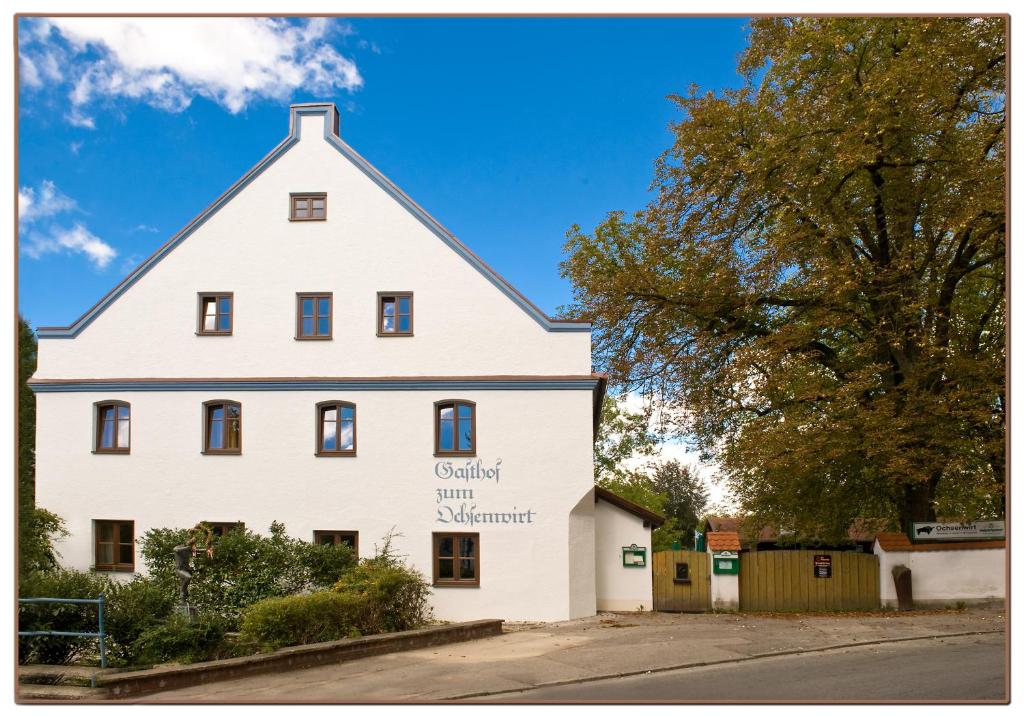 a white house with a sign on the side of it at Gasthaus Ochsenwirt in Landshut