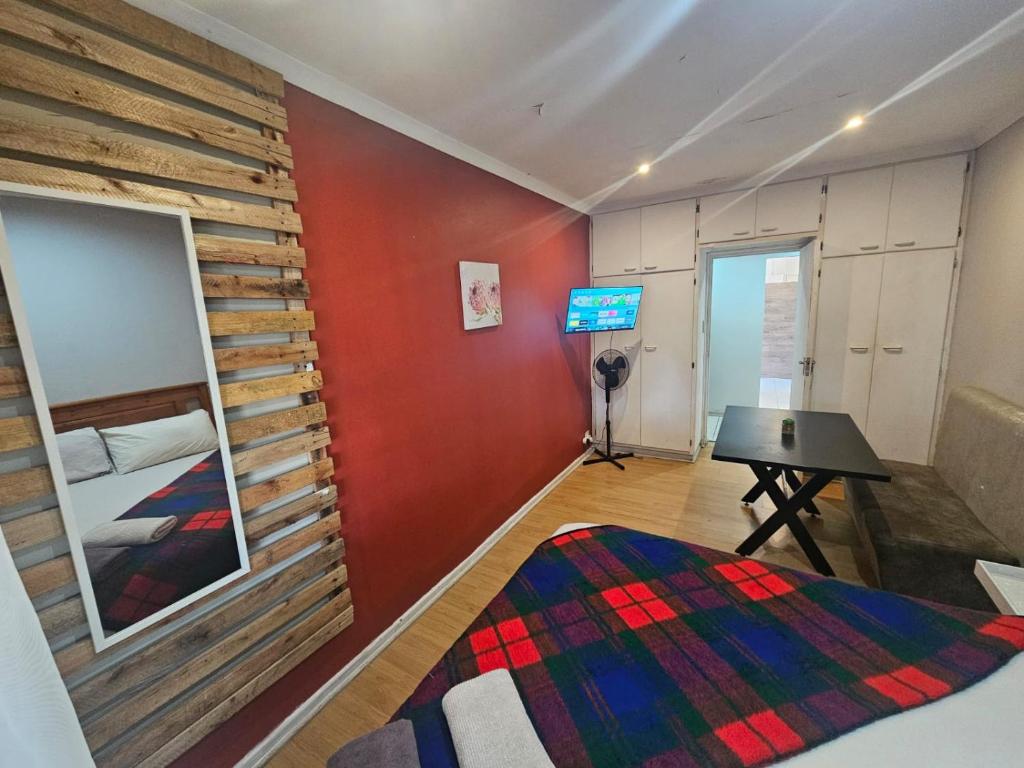 a bedroom with a wooden accent wall and a table at Stay at 126 in Bloemfontein