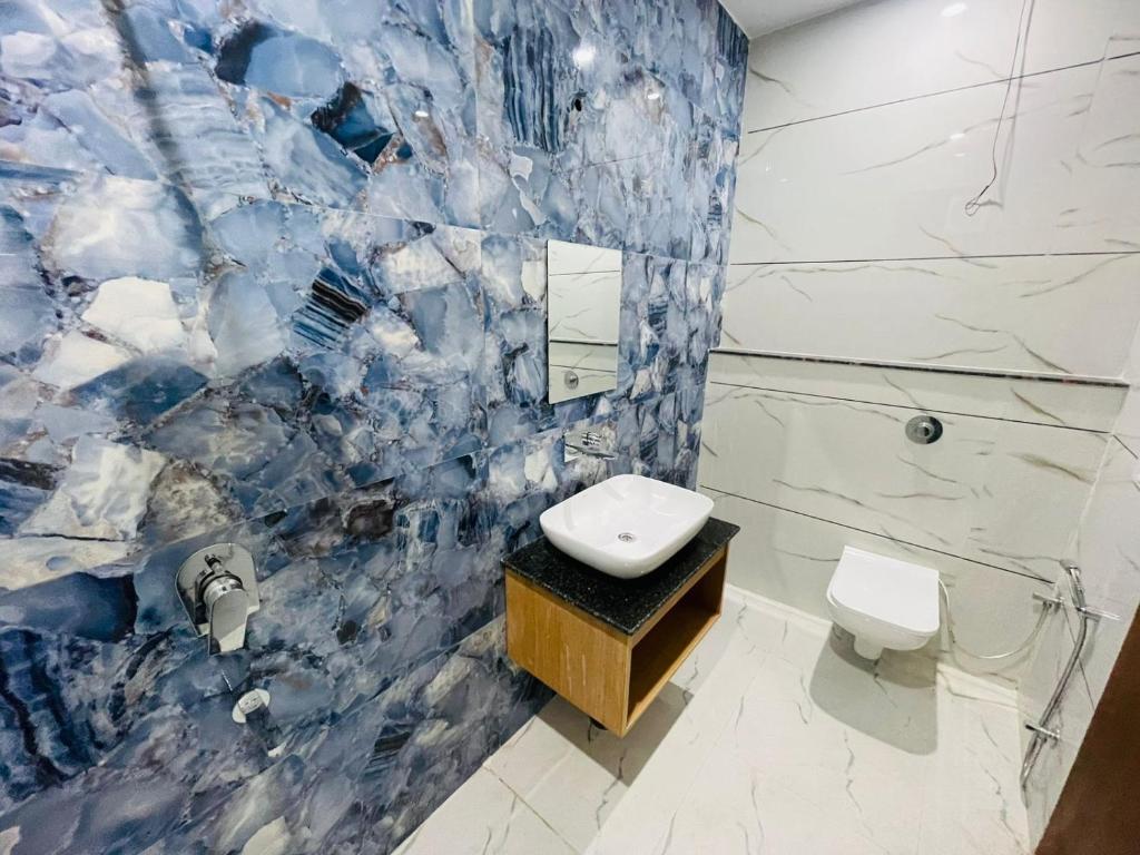 a blue and white bathroom with a toilet and a sink at Hotel Pilgrim walking distance From Golden Temple in Amritsar