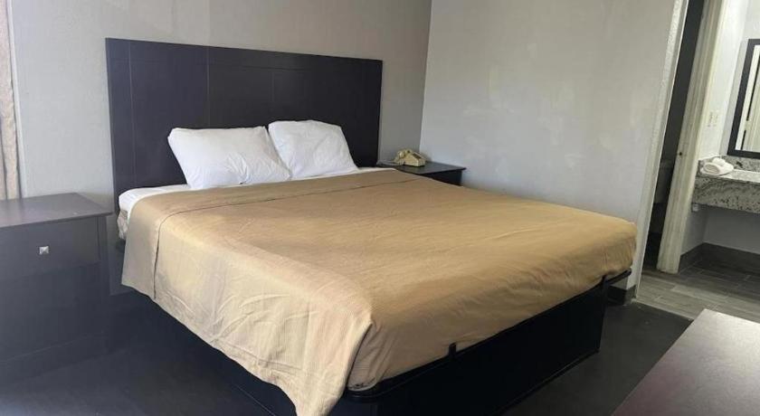 a bedroom with a large bed with two pillows at Scottish Inns Augusta in Augusta