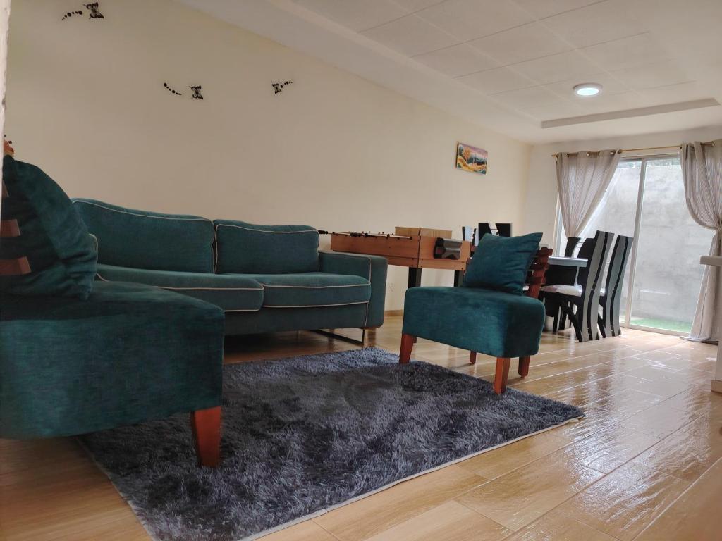 a living room with a couch and chairs and a table at Dulce Hogar 01 in Loja