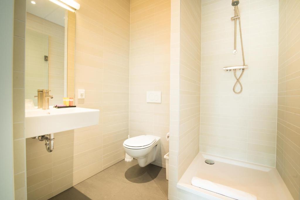 a white bathroom with a toilet and a sink at Citiez Hotel Amsterdam in Amsterdam